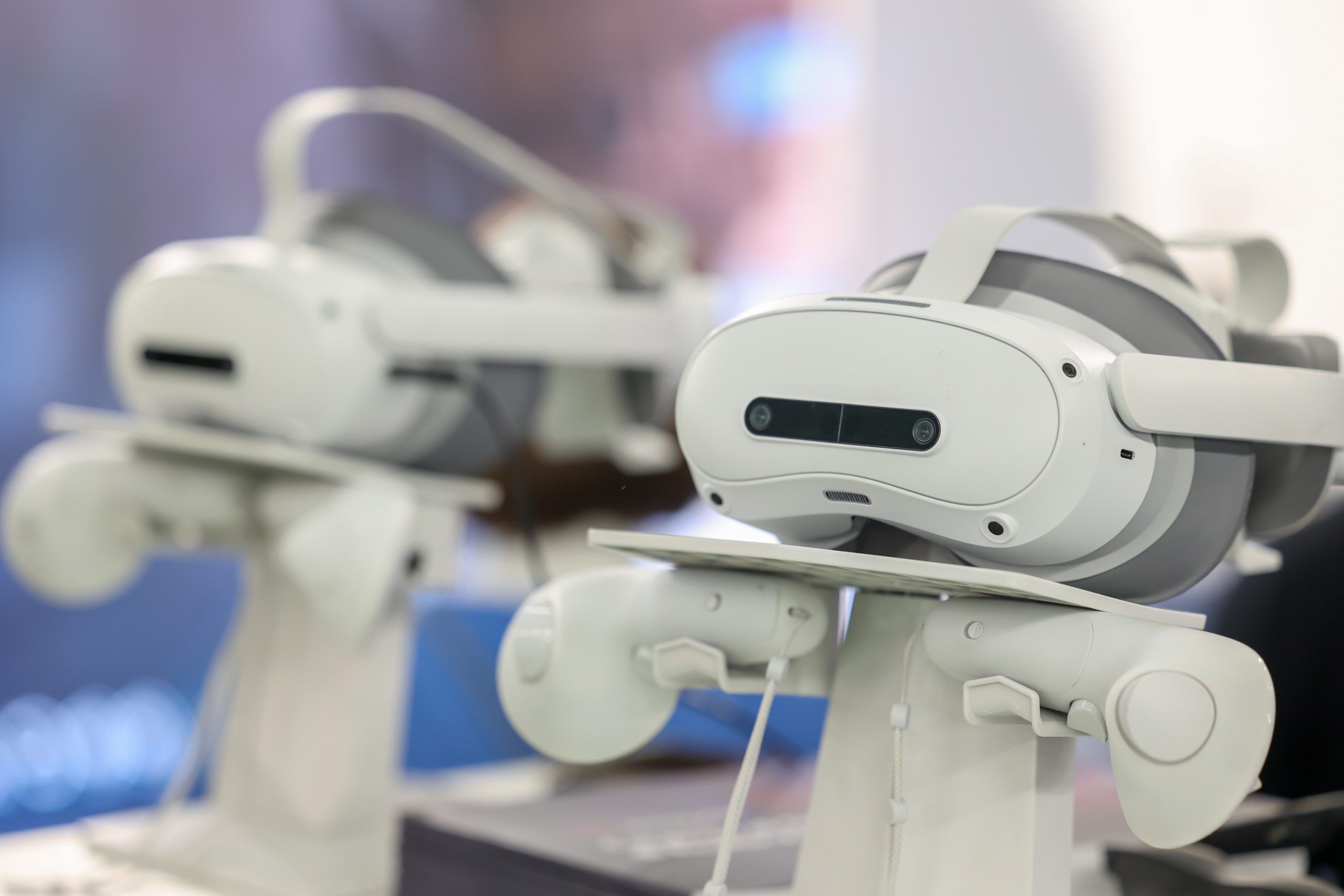 Due visori per la realtà virtuale bianchi esposti su supporti durante un evento.